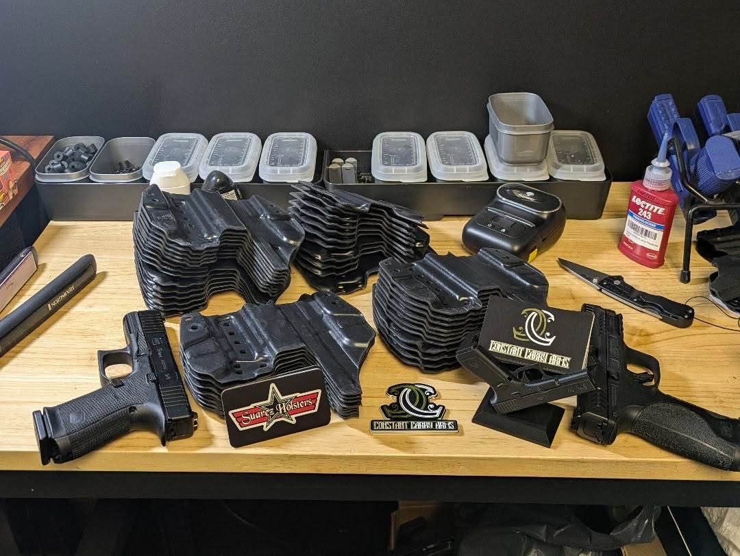 Custom Kydex holsters and pistols on workbench