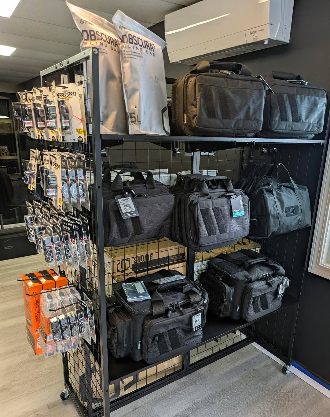 Range bags, sling bags, and pepper spray display rack